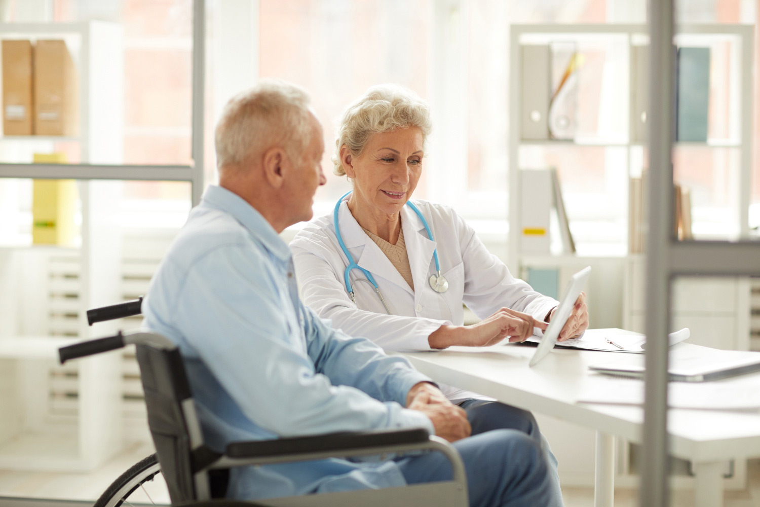 Ärztin erklärt Patienten etwas mit einem Tablet