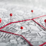 Stadtplan mit roten Stecknadeln und roten Fäden