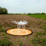 Drohne schwebt über einem Acker