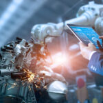 Mann mit Tablet steuert Roboter in der Produktion