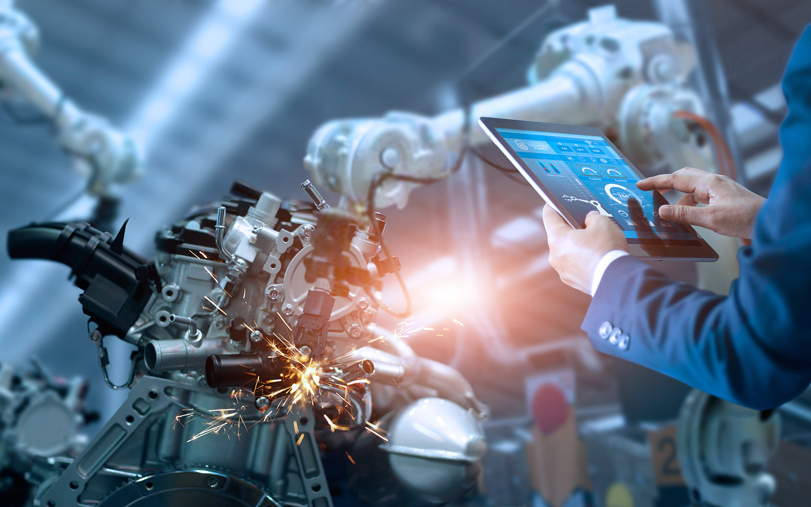 Mann mit Tablet steuert Roboter in der Produktion
