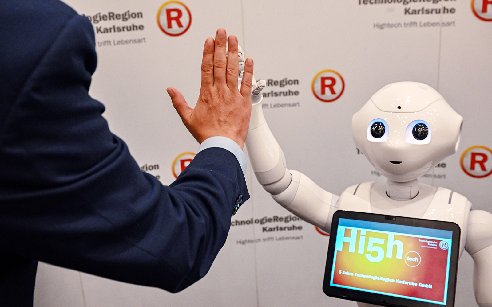 High5 Handschlag mit KIT-Roboter Pepper zum 5jährigen Jubliläum der TRK GmbH