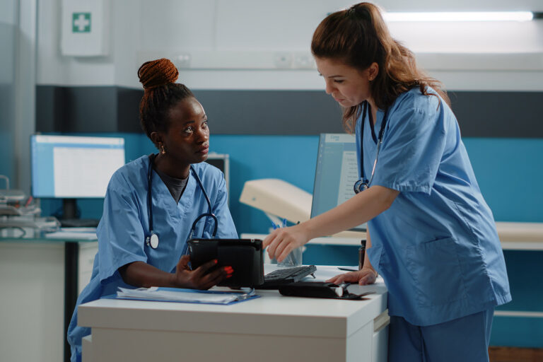 projekt-bild-pfledaki Team von Krankenschwestern, die ein Tablet mit Touchscreen für Untersuchungen und Termine verwenden.