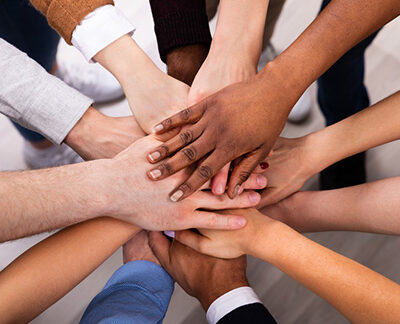 Mehrere Personen legen die Hände übereinander