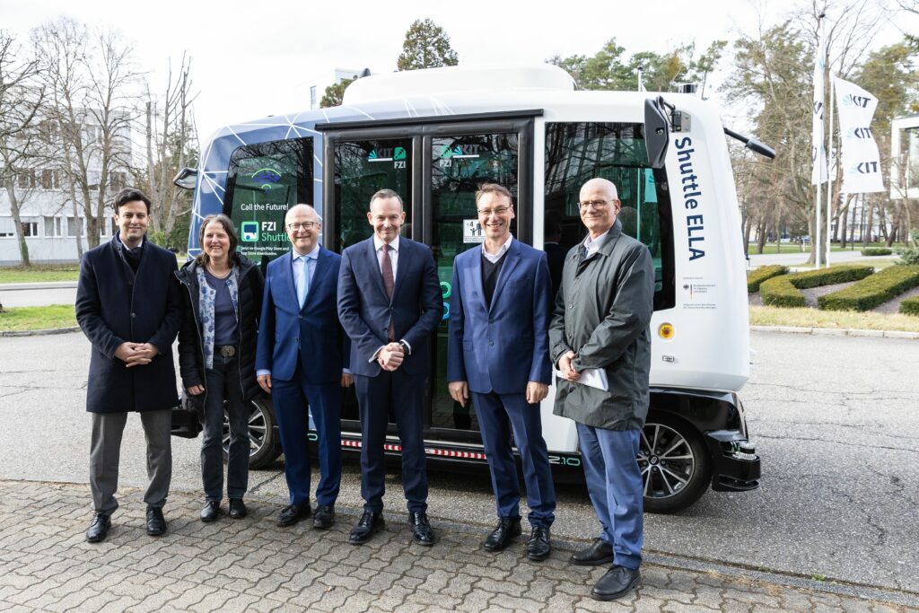 Verkehrsminister Wissing zu Besuch am KIT, stehend vor dem FZI-Shuttle